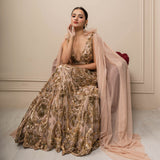 Woman in a gold sequin gown with a pink shawl against a beige wall.