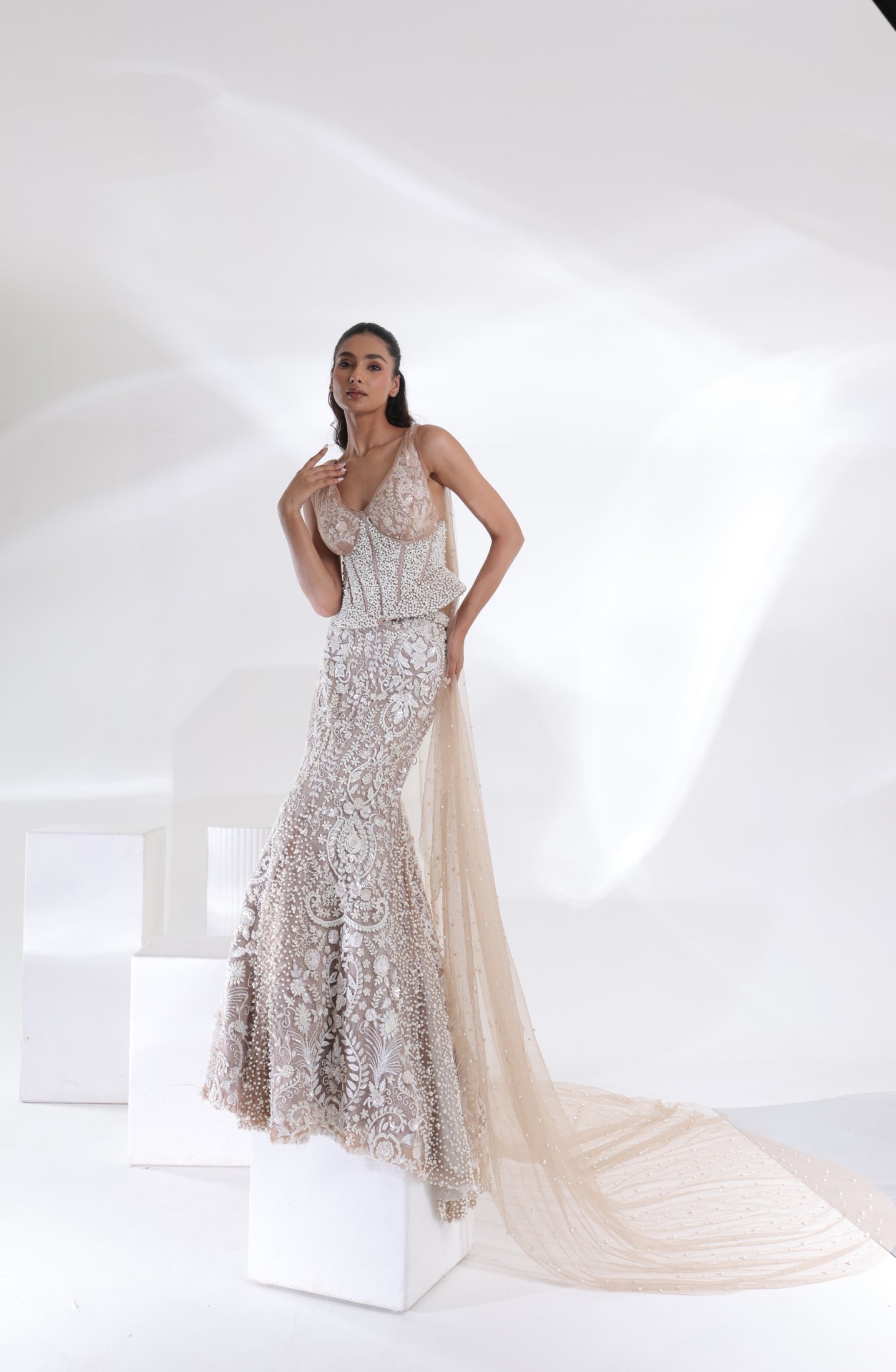 Back view of the Aurelia Pearl Mermaid Lehenga showcasing the long champagne ivory net veil with scattered pearl embellishments, dramatic trailing length and embroidered mermaid skirt by DEEPANSHI MASSEY LABEL.