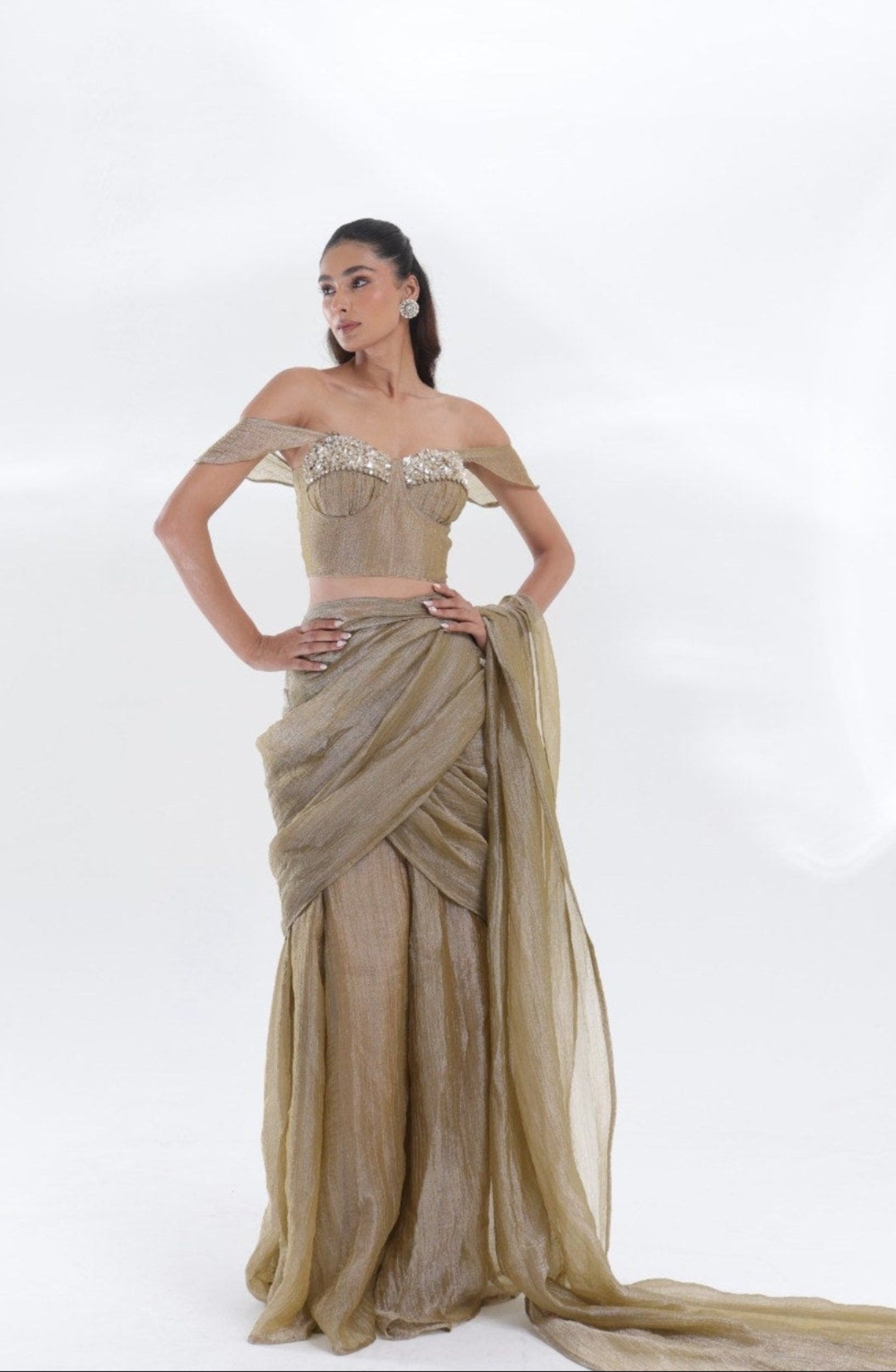Aurum Tissue Silk Saree by DEEPANSHI MASSEY LABEL featuring a luxurious metallic-gold drape, structured off-shoulder corset blouse and an elegant silhouette with a flowing pallu.