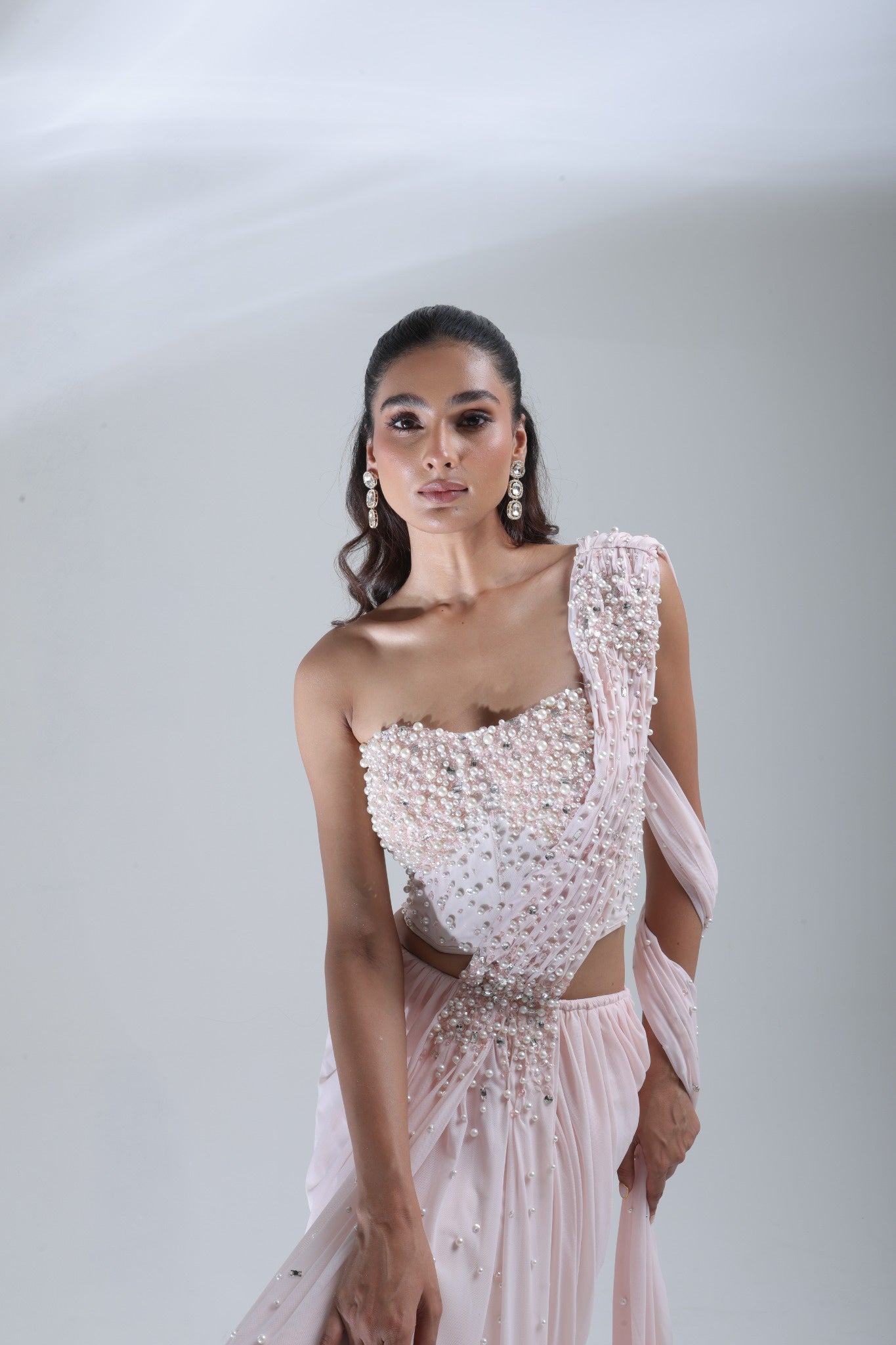 DEEPANSHI MASSEY LABEL close-up of baby pink saree lehenga blouse with dense pearl and crystal embellishments and decorated pallu
