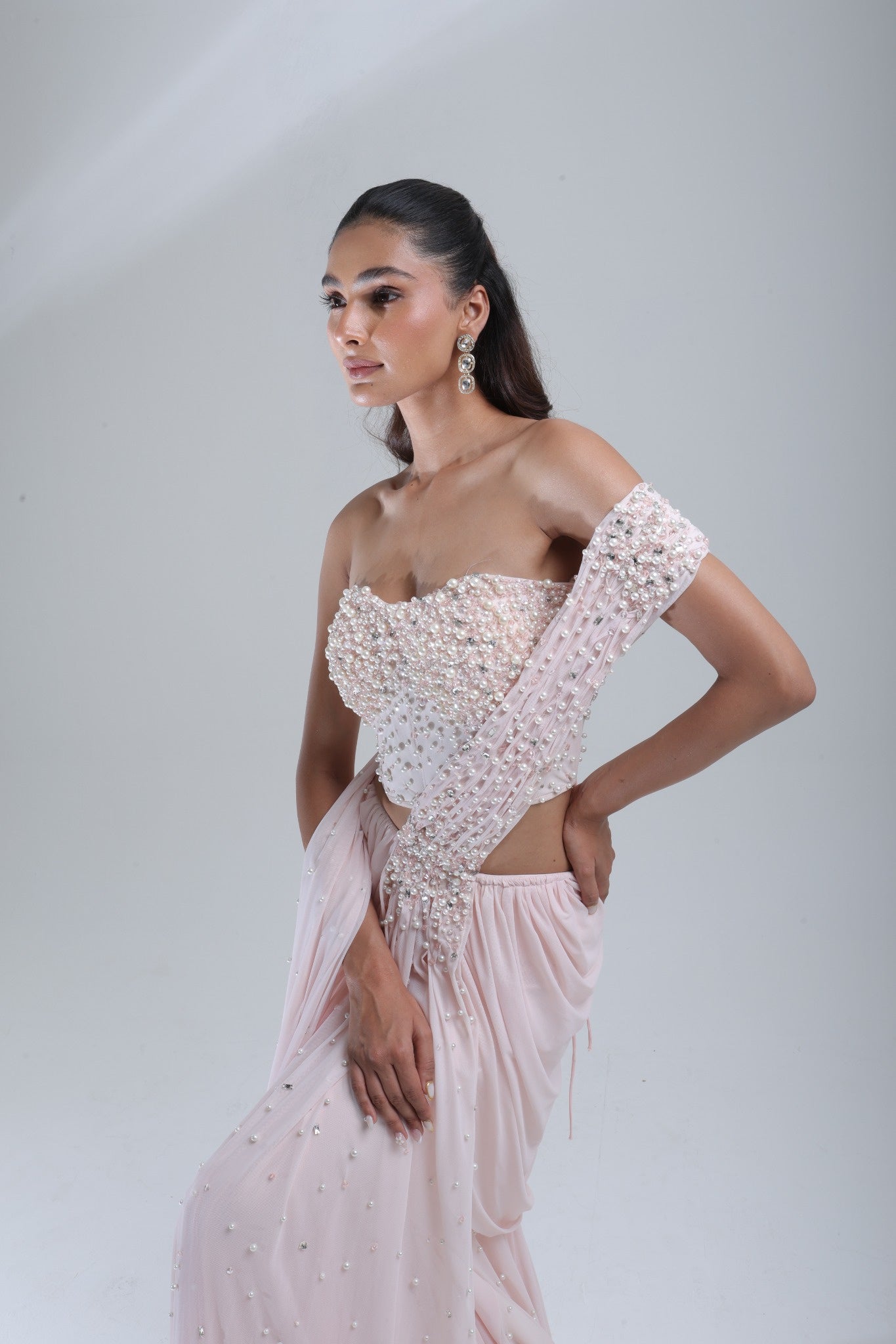 DEEPANSHI MASSEY LABEL side-angle close-up of baby pink saree lehenga with pearl-embellished blouse and statement draped pallu