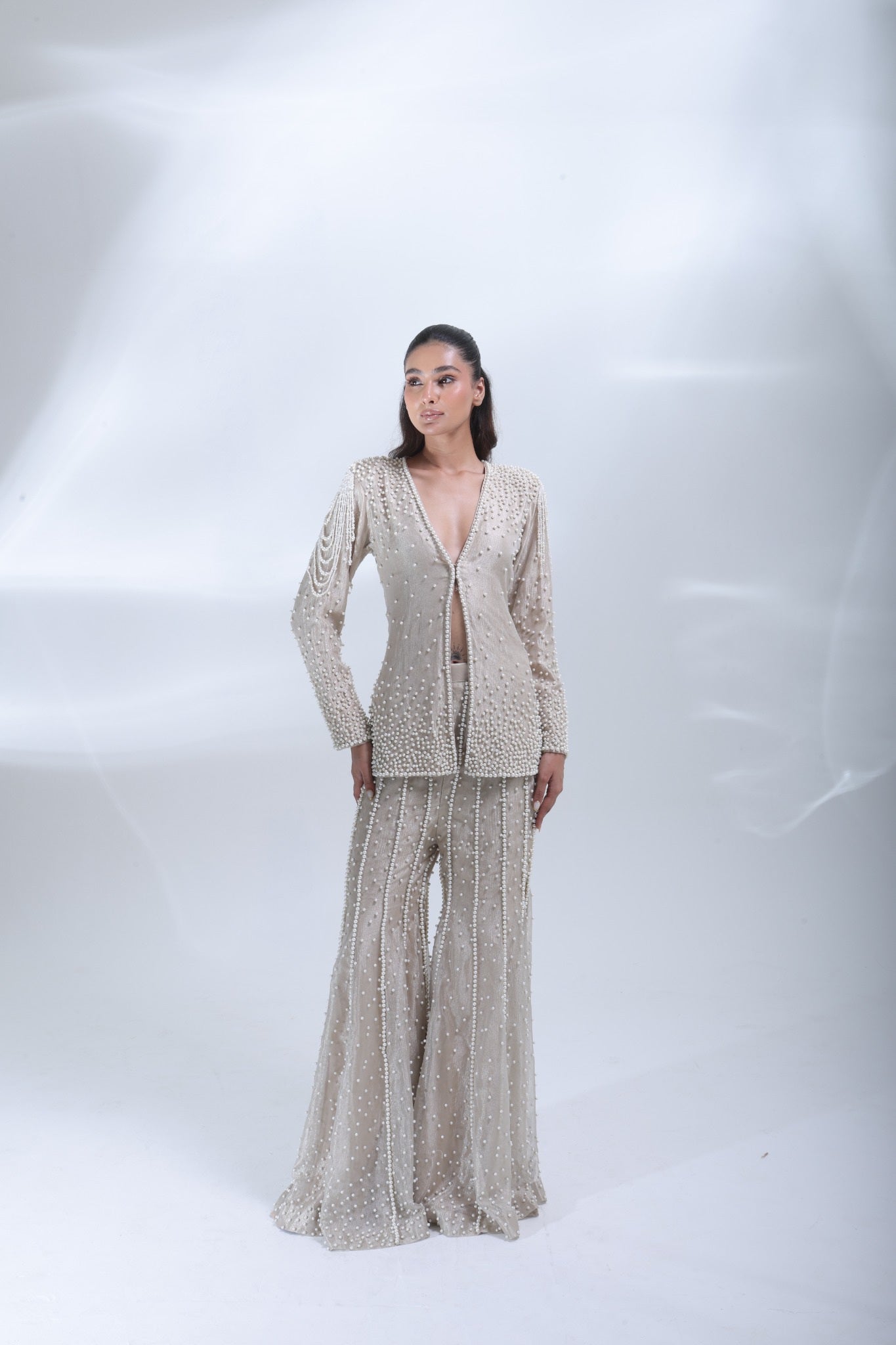 Front view of the champagne pearl co-ord set featuring a deep V-neck jacket and embellished flared trousers.